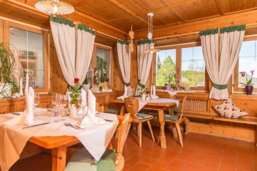 佩尔卡Naturhotel Miraval的用餐室设有桌椅和窗户。