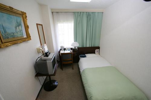 米泽市平成商务酒店的酒店客房设有两张床和电视。