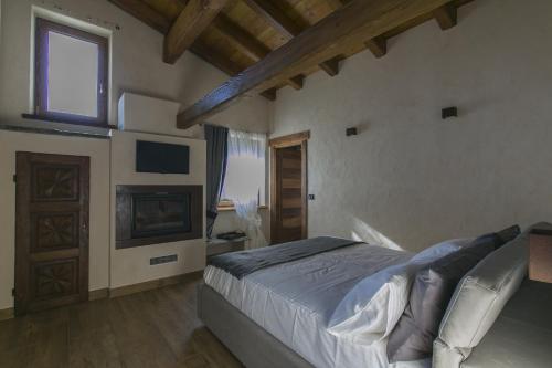 ChambaveB&B Lo Matsòn的一间卧室配有一张床、一个壁炉和一台电视。