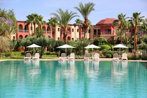 马拉喀什Iberostar Waves Club Palmeraie Marrakech All Inclusive的度假村前方的带椅子和遮阳伞的游泳池