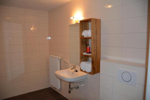黑泽2 persoons appartement的浴室设有水槽和带毛巾的架子。