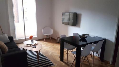 布宜诺斯艾利斯Apartamento Las Heras的客厅配有黑桌和白色椅子