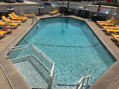 怀尔德伍德Starfire Motel的一座大型游泳池,里面设有黄色椅子