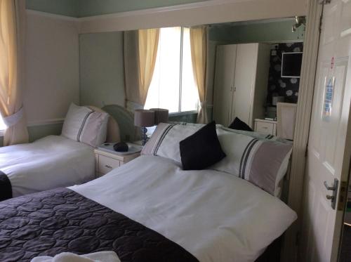 普里茅斯Alma Lodge Guest House的酒店客房,设有两张床和镜子