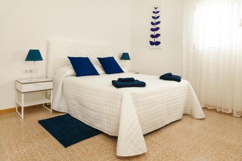 卡门港Apartamento Filla的卧室配有白色床和蓝色枕头