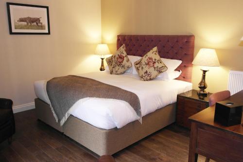 West Meon托马斯勋爵宾馆的一间卧室配有一张大床和两盏灯