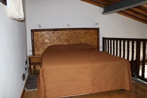 阿格罗斯AgroSpito Traditional Guest House的一间卧室配有一张带木制床头板的床
