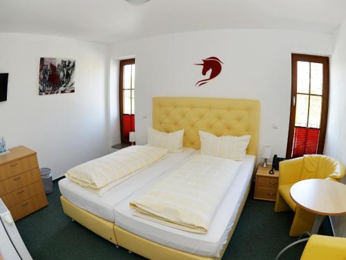 都伦-埃菲尔Hotel-Restaurant Rotes Einhorn Düren *** Superior的一间卧室配有一张大床和一张黄色椅子
