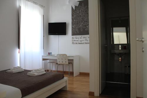 卡利亚里卡利亚里I'MC IoAMo旅馆的一间卧室配有一张床、一张书桌和一个窗户。