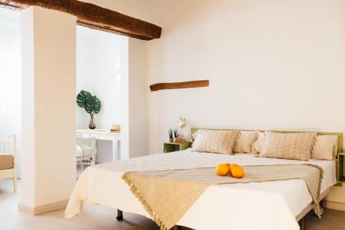 瓦伦西亚奥图魅力旅馆的一间白色的卧室,配有一张带两个南瓜的床