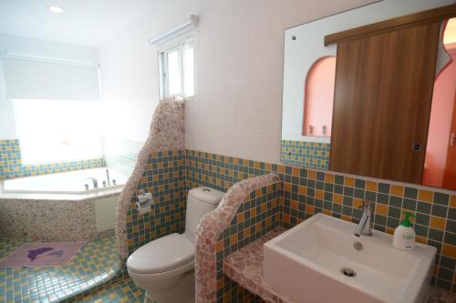 鹅銮鼻加利利民宿的一间带水槽、卫生间和镜子的浴室