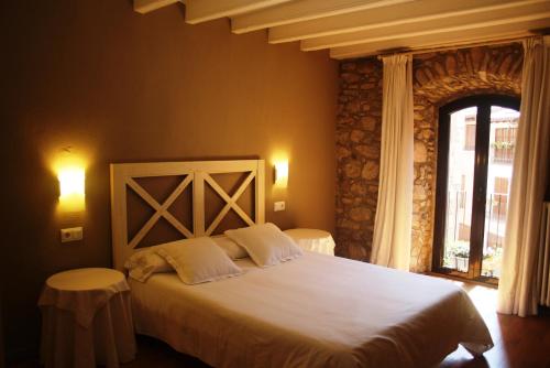 拉波夫拉-德利列特El Castell de la Pobla de Lillet (Adults Only)的一间卧室设有一张大床和一个窗户。
