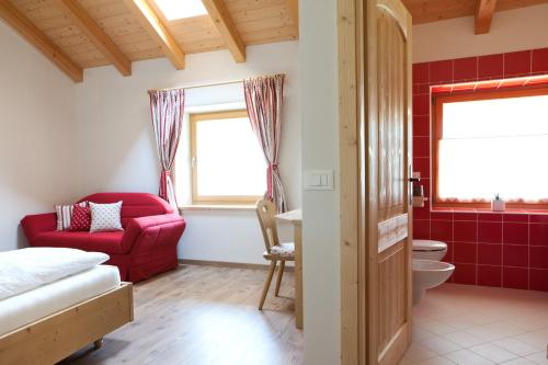 Roncegno克罗纳塔住宿加早餐旅馆的一间带红色沙发和红色椅子的浴室
