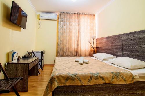 阿斯塔纳贝莱科特旅馆的一间卧室配有一张床、一张书桌和一台电视
