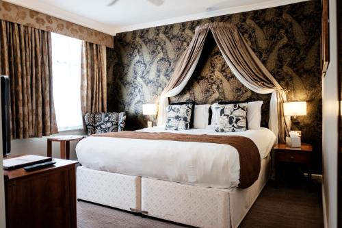 伦敦富勒疯帽子酒店的一间卧室配有一张带天蓬的大床