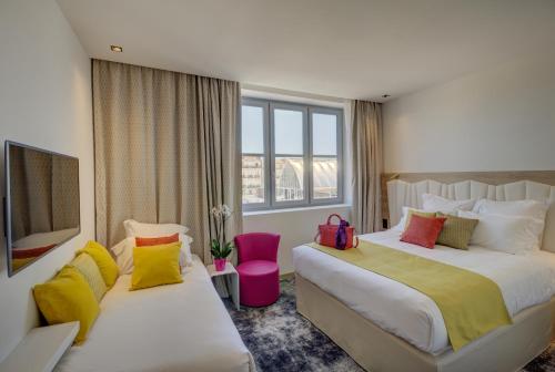 蒙彼利埃圣罗奇喜剧贝斯特韦斯特优质酒店的酒店客房配有两张带色彩缤纷枕头的床。