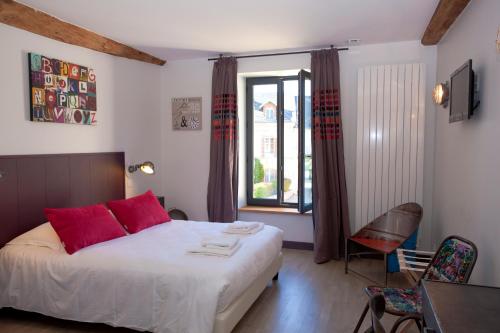 Saint-MesmesLes Tournelles - Chambres d'hôtes的一间卧室配有一张带红色枕头的床和一扇窗户