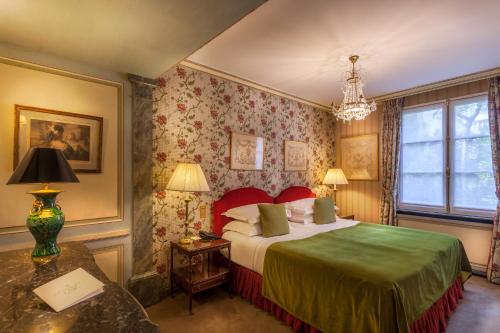 巴黎杜克圣西蒙酒店的一间卧室配有一张床和一张带台灯的桌子