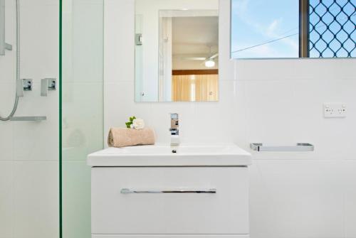 麦夸里港Beauty at the Beach - modern beachfront apartment的白色的浴室设有水槽和淋浴。
