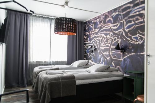基律纳SPiS旅馆的一间卧室配有两张床和壁画
