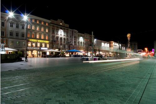 林茨Austria Classic Hotel Wolfinger - Hauptplatz的夜色浓厚的城市街道