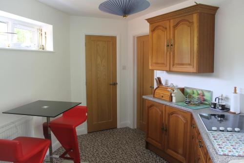 伊利Pear Tree House Studio的厨房配有桌子和红色凳子