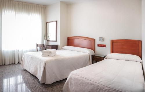 蓬费拉达Hostal San Miguel的酒店客房设有两张床和窗户。