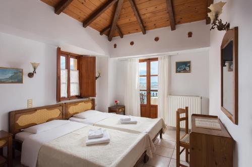 莫奈姆瓦夏佩特里诺旅馆的一间卧室配有两张床和一张桌子及椅子