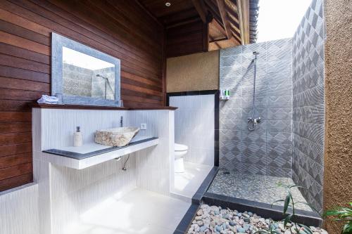 蓝梦岛隆堡冈古邦小屋度假村的带淋浴、卫生间和镜子的浴室