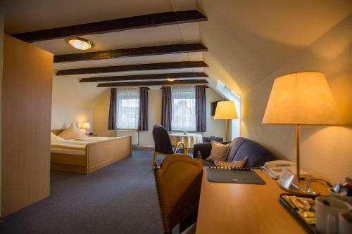 博尔库姆瓦尔德泽格拉芙酒店的配有一张床和一张书桌的酒店客房