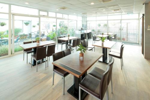 永康永康剑桥大饭店的餐厅设有桌椅和大窗户。