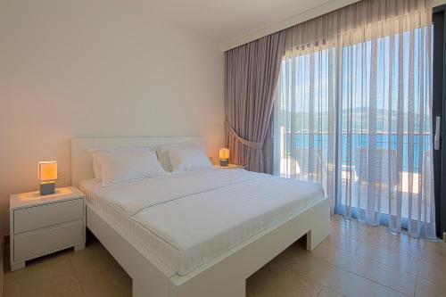 蒂瓦特Villa Krasici的一间卧室设有一张大床和一个大窗户