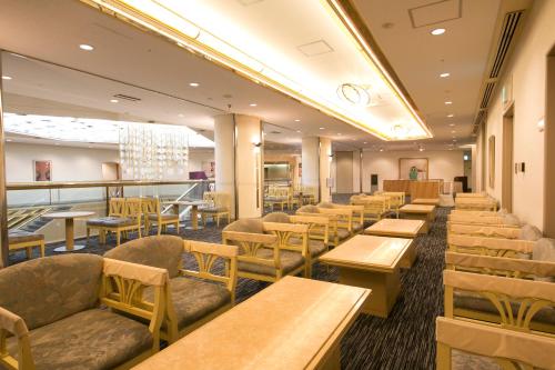 大阪新大阪华盛顿广场酒店的一间带木桌和椅子的餐厅和一间自助餐厅