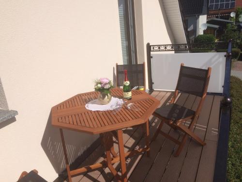 劳特尔巴赫Gästehaus am Fischerweg的阳台上配有一张木桌和两把椅子
