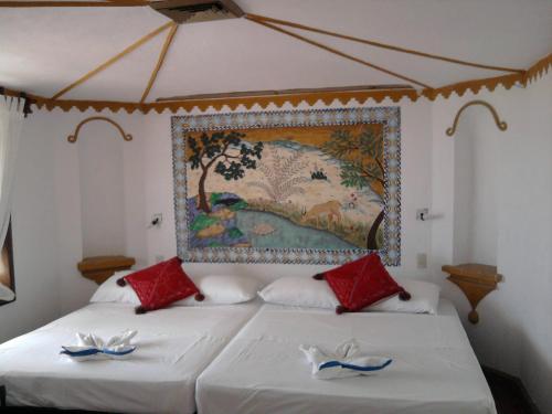 埃斯孔迪多港埃斯孔迪多帕拉伊索酒店的一间卧室配有两张床,墙上挂着一幅画
