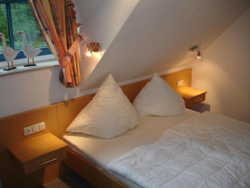 坡瑟利特兹Puddemin Haus Malve 2的一间卧室配有带两个枕头的床和窗户