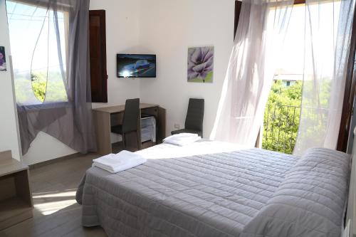 特罗佩阿B&B Solandra的一间卧室配有一张床、一张书桌和一台电视
