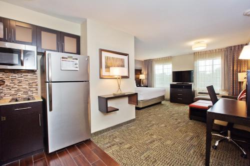 奥斯汀Staybridge Suites Austin South Interstate Hwy 35, an IHG Hotel的酒店客房设有冰箱和一间卧室。