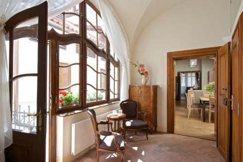 布拉格优梅森纳瑟公寓式酒店的走廊设有门、桌子和椅子