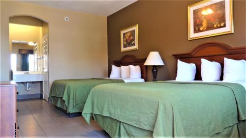 麦卡伦La Copa Inn的酒店客房,配有两张带绿床单的床