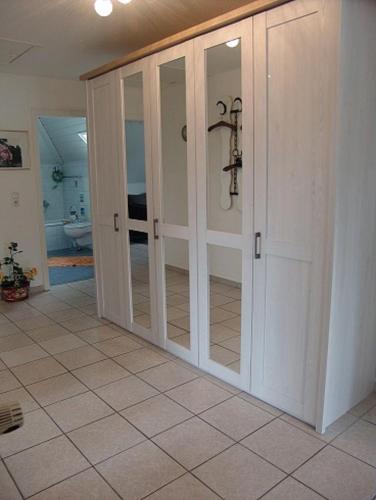 比苏姆Haus-Norderpiep的客房铺有瓷砖地板,设有滑动玻璃门。