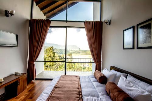 努沃勒埃利耶邦格罗度假屋的一间卧室设有一张床和一个大窗户