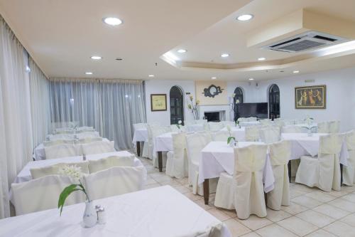普拉坦斯Creta Aquamarine Hotel的宴会厅配有白色的桌子和白色的椅子