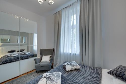 索波特Platinum Chmielewskiego的卧室配有床、椅子和窗户。