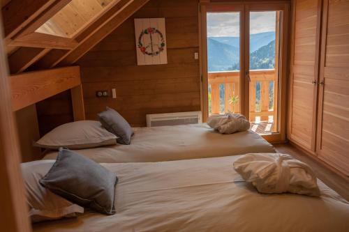 穆巴赫索蒙斯特La Cabane de Tim的带窗户的客房内的两张床