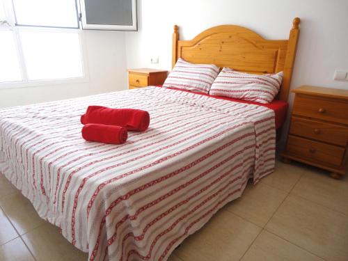 罗萨里奥港Apartamento aeropuerto playa的一间卧室配有一张带红色毛巾的床