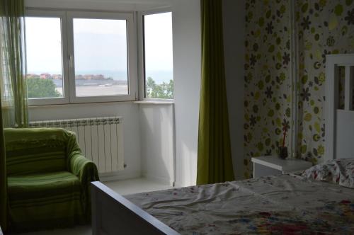 康斯坦察Apartament Faleza Nord的一间卧室配有一张床、一把椅子和窗户。