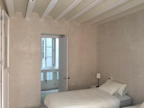 加的斯Casa Bugambilla Cadiz的白色的卧室设有床和窗户