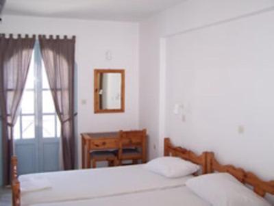 卡利诺岛帕诺拉马酒店的一间卧室设有两张床、一张桌子和一个窗口
