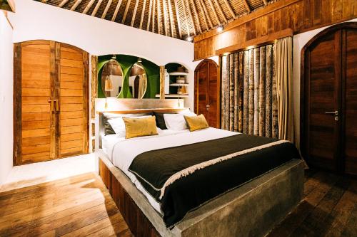 吉利特拉旺安马约私人别墅的卧室配有一张床铺,位于带木墙的房间内